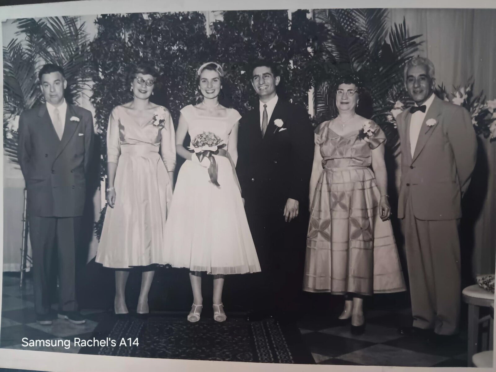 A formal black-and-white group photograph from Toby and Ray&rsquo;s wedding.
