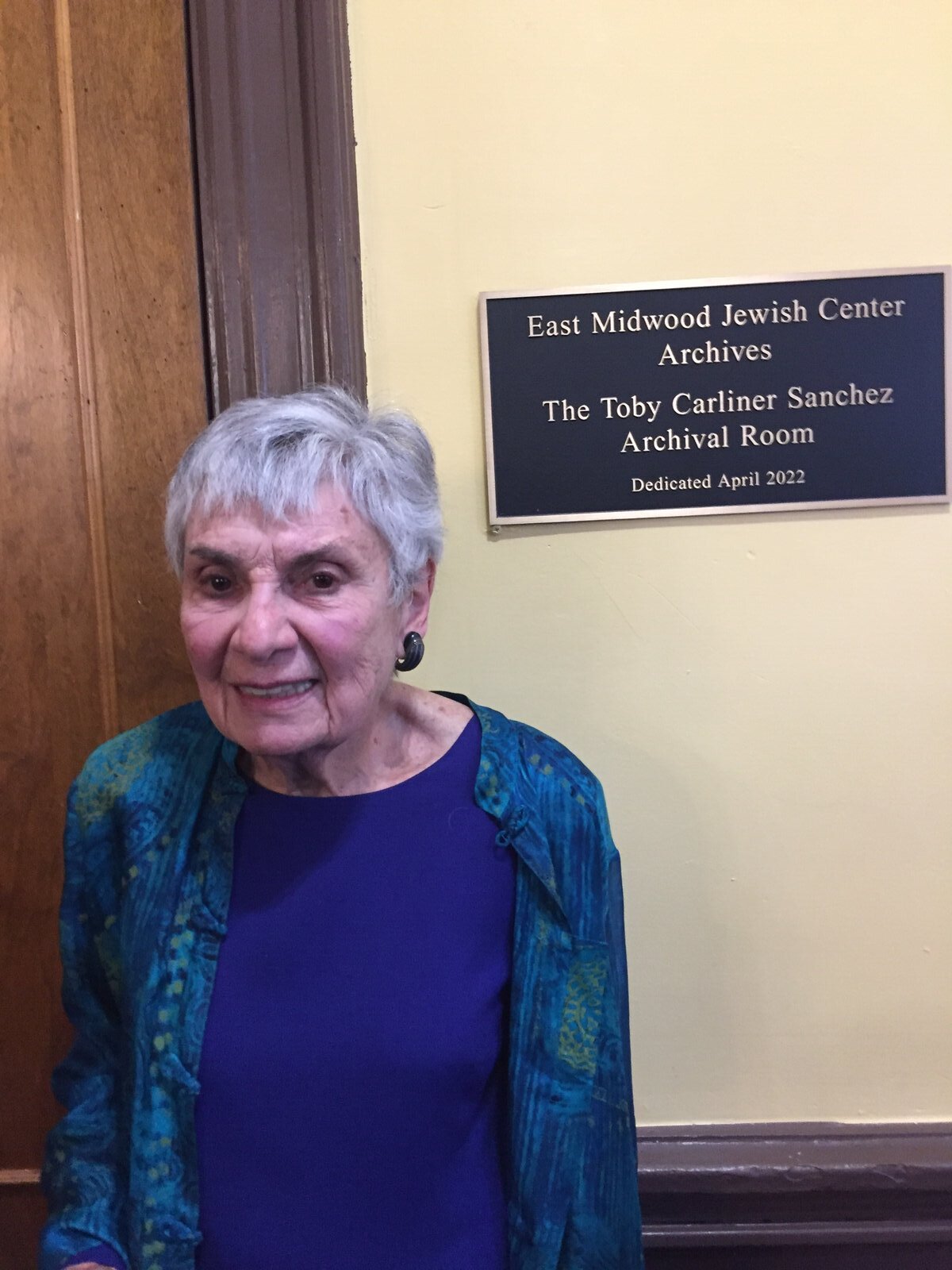 Toby beside the plaque dedicating the archival room in her name.